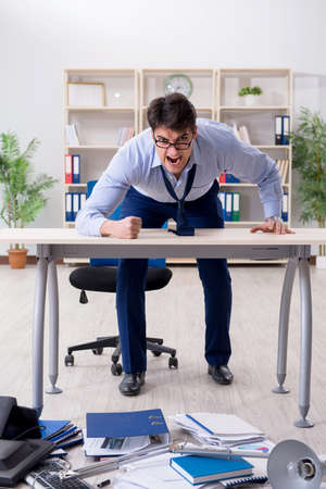 Angry businessman frustrated with too much workの写真素材