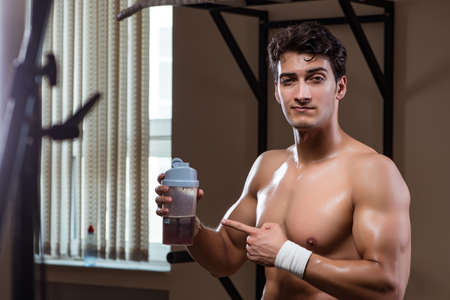 Man with nutrient supplements in sports gym