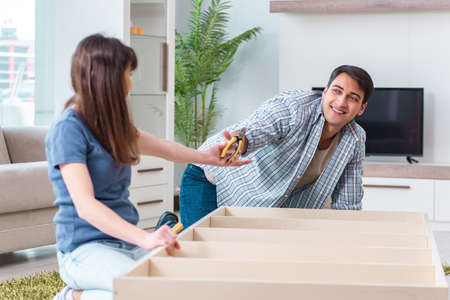 Young family assembling furniture at new houseの写真素材