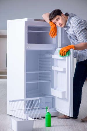 Man cleaning fridge in hygiene conceptの写真素材