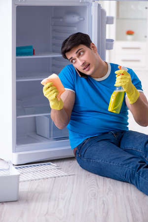 Man cleaning fridge in hygiene conceptの写真素材