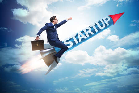 Businessman in start-up concept flying on rocketの写真素材