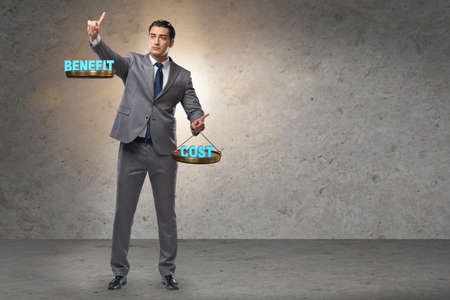Businessman in cost benefit balance conceptの写真素材