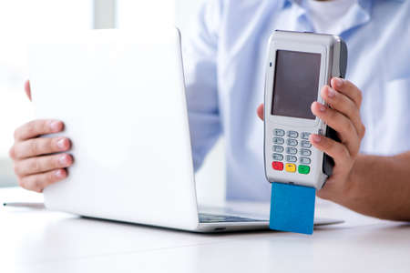 Man processing credit card transaction with POS terminalの写真素材