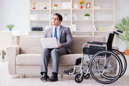 Dsabled businessman on wheelchair working homeの写真素材