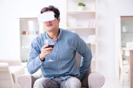 Young man drinking wine at home