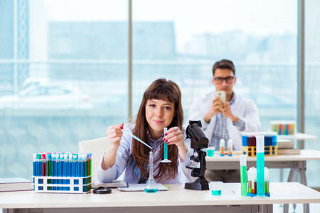 Two chemists working in lab experimenting