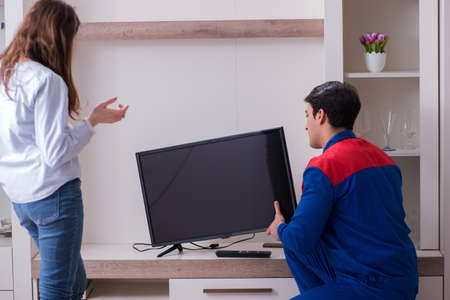Tv repairman technician repairing tv at homeの写真素材