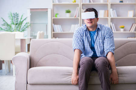 Man with virtual reality glasses playing at home