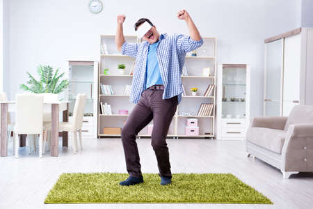 Man with virtual reality glasses playing at homeの写真素材