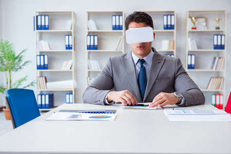Businessman with virtual reality glasses in the officeの写真素材