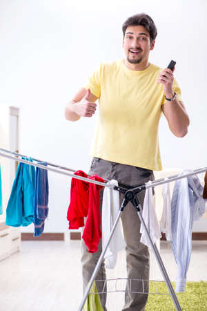 Handsome man husband doing laundering at homeの写真素材