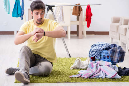 Handsome man husband doing laundering at homeの写真素材