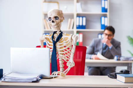 Businessman working with skeleton in office