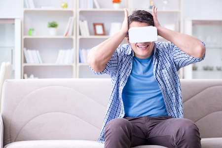 Man with virtual reality glasses playing at home