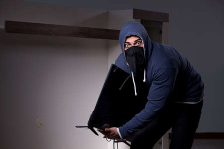 Burglar thief stealing tv from apartment houseの写真素材
