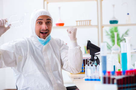 Young chemist student working in lab on chemicalsの写真素材