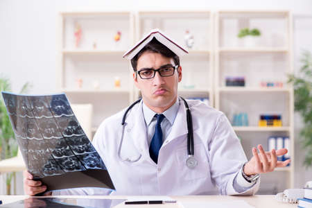 Young doctor looking at x-ray images in clinicの写真素材