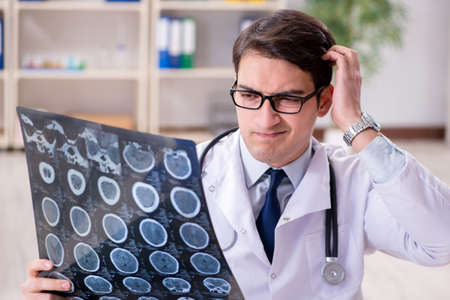 Young doctor looking at x-ray images in clinic