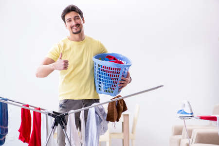 Handsome man husband doing laundering at homeの写真素材