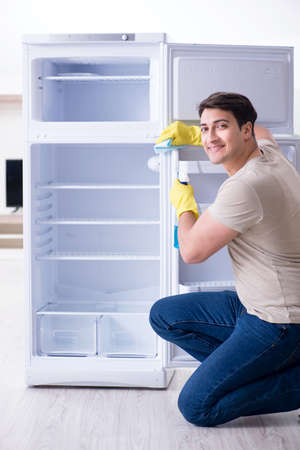 Man cleaning fridge in hygiene conceptの写真素材
