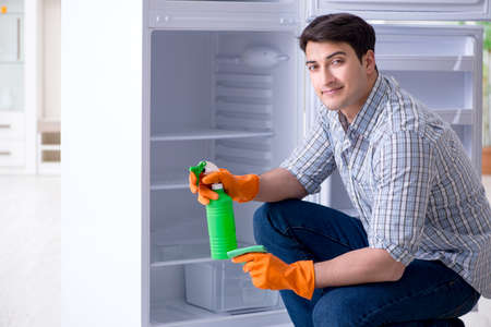 Man cleaning fridge in hygiene conceptの写真素材