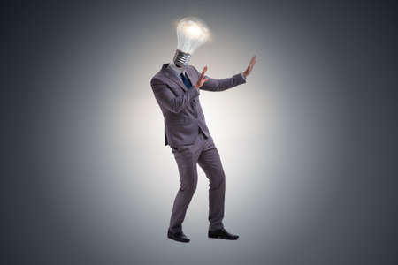 Businessman in bright idea concept with lightbulb headの写真素材