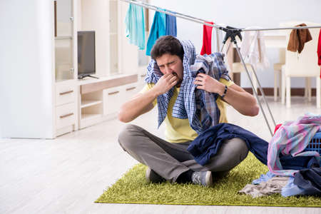 Handsome man husband doing laundering at homeの写真素材