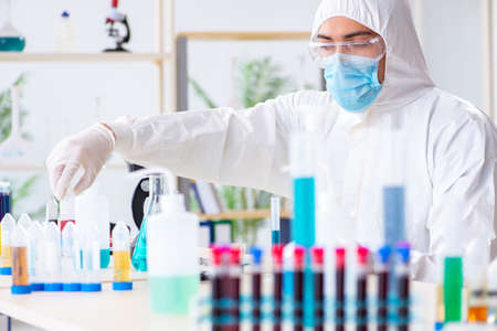 Young chemist student working in lab on chemicals
