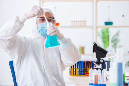 Young chemist student working in lab on chemicals