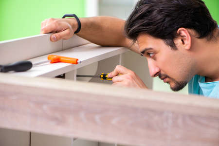 Man repairing furniture at homeの写真素材