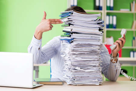 Businessman having problems with paperwork and workloadの写真素材