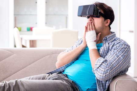 Man with hand injury wearing virtual reality glasses