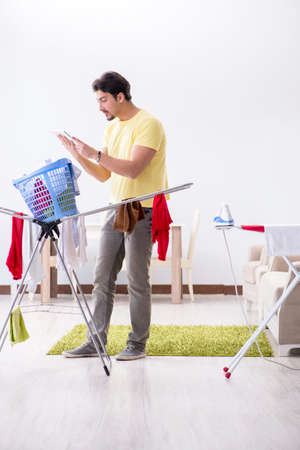 Handsome man husband doing laundering at homeの写真素材