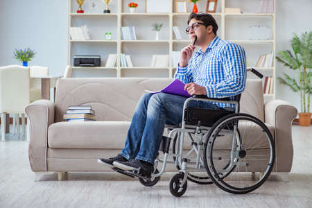 Young student on wheelchair in disability conceptの写真素材