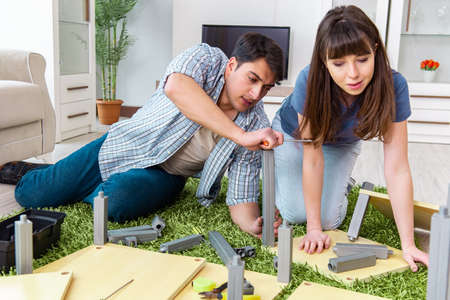 Young family assembling furniture at new houseの写真素材