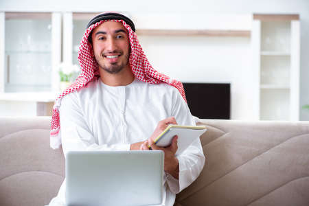 Arab man working at home on his workの写真素材