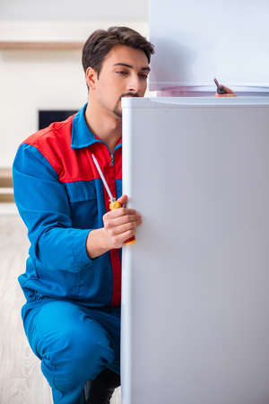 Professional contractor repairing broken fridgeの写真素材