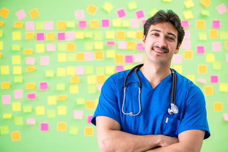 Young doctor with many reminders and urgent workの写真素材