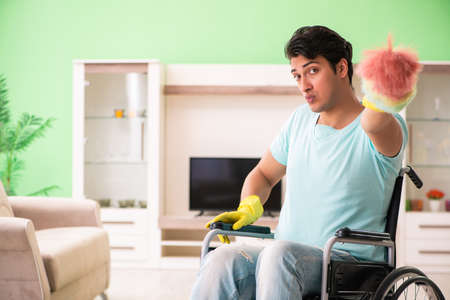 Disabled man on wheelchair cleaning house