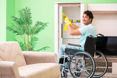 Disabled man on wheelchair cleaning houseの写真素材