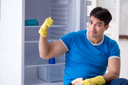 Man cleaning fridge in hygiene conceptの写真素材