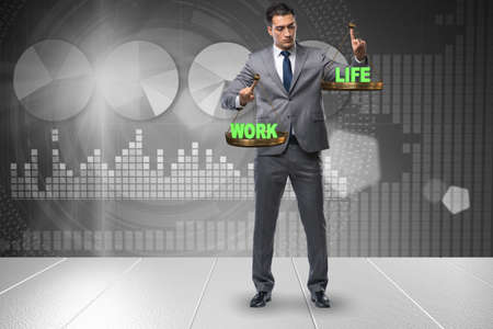 Businessman trying to find balance between home and workの写真素材