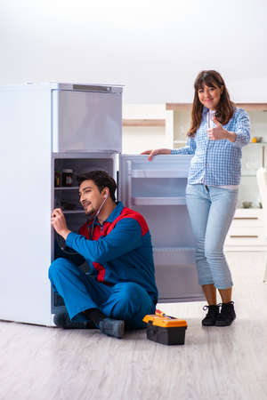 Man repairing fridge with customerの写真素材