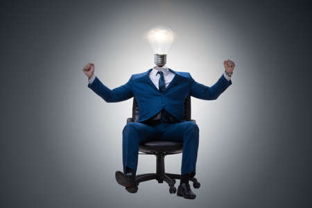 Businessman in bright idea concept with lightbulb headの写真素材