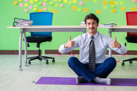 Man in the office with many conflicting priorities doing exercisの写真素材