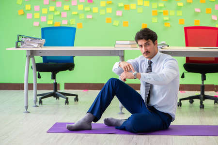 Man in the office with many conflicting priorities doing exercisの写真素材