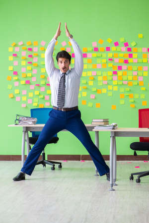 Man in the office with many conflicting priorities doing exercisの写真素材