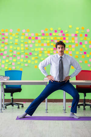 Man in the office with many conflicting priorities doing exercisの写真素材