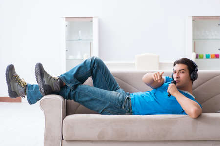 Young handsome man singing karaoke at homeの写真素材